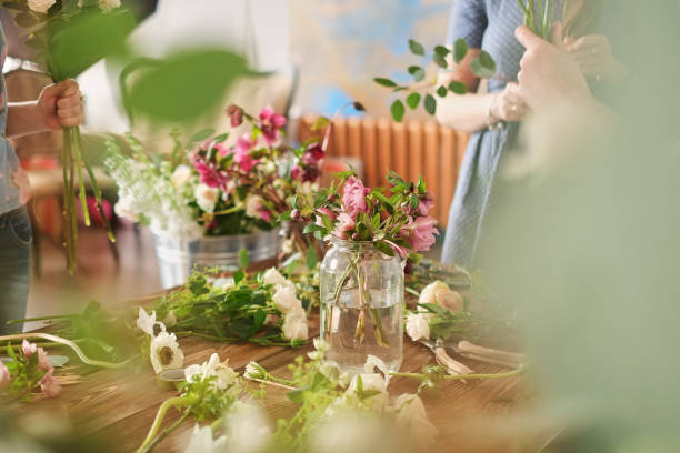 istock hands of florist collect wedding bouquet at work 1082353748
