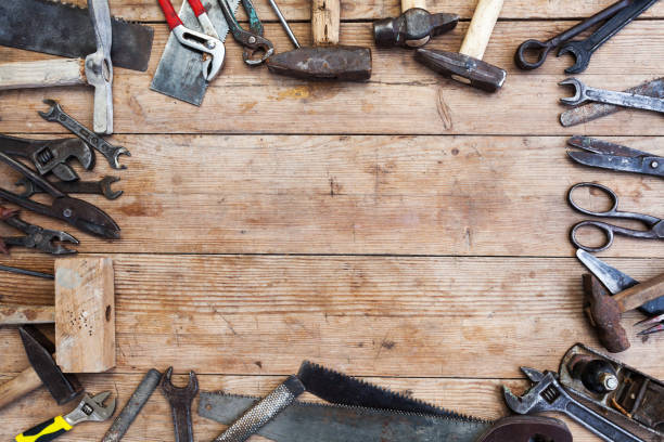 istock Composition of construction tools on an old battered wooden surface of tools: pliers, pipe wrench, screwdriver, hammer, metal shears, saws 1082357630