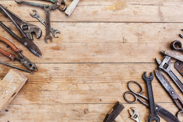 istock Composition of construction tools on an old battered wooden surface of tools: pliers, pipe wrench, screwdriver, hammer, metal shears, saws. 1082357710