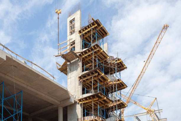 istock Residental building under construction. Precast concrete stairs installed. Walls made of aerated concrete blocks. Crane and new mutlistoty building construction site. Construction of staircases. 1082359012