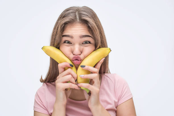 istock Playful young woman lok on camera. She press cheeks with it. Model grimace. Isolated on white background. 1082362224