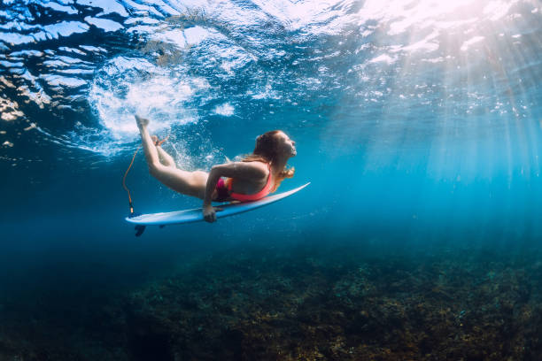 istock Surfer woman dive underwater with under wave. 1082362760
