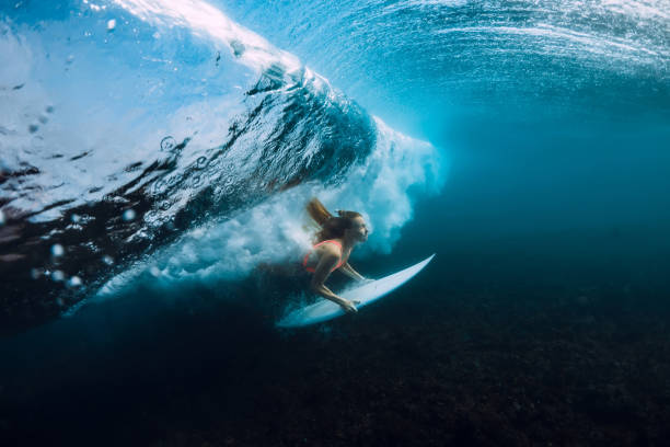istock Attractive surfer woman dive underwater, under barrel wave in blue ocean 1082363908