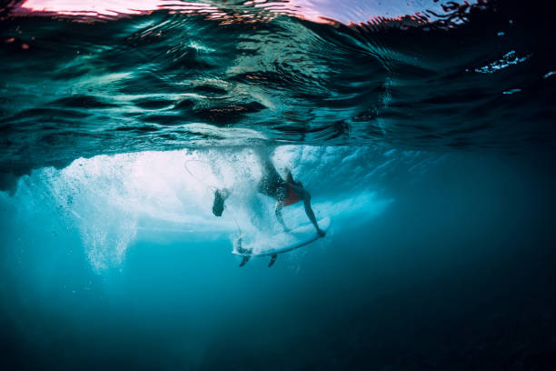 istock Attractive surfer woman dive underwater with under barrel wave. 1082363928