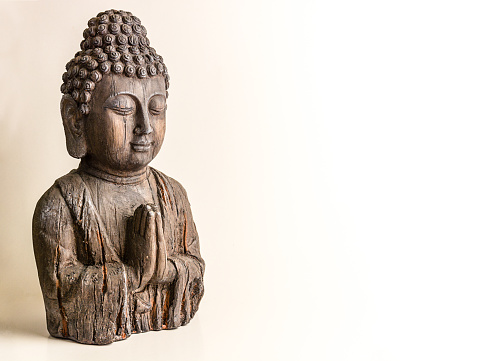 Lateral view of an isolated buddha bust on a white background