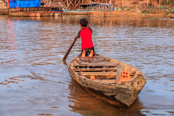 istock Cambodian young boy rowing a boat, Tonle Sap, Cambodia 1082367560