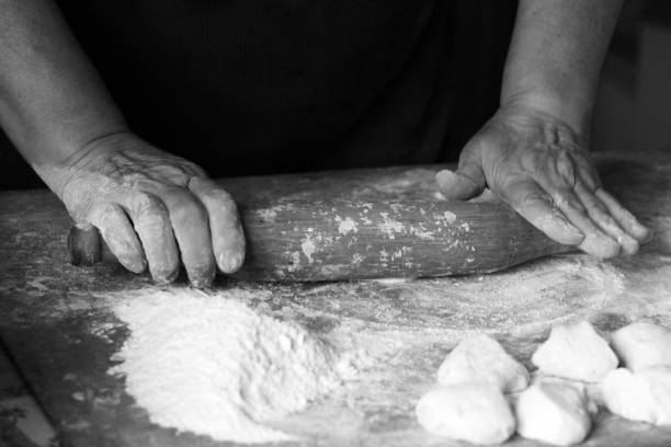 istock Female hands making dough for pizza, black and white 1082369194