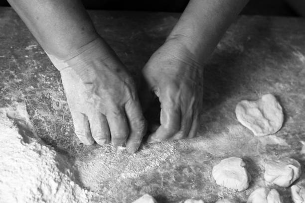 istock Female hands making dough for pizza, black and white 1082369208