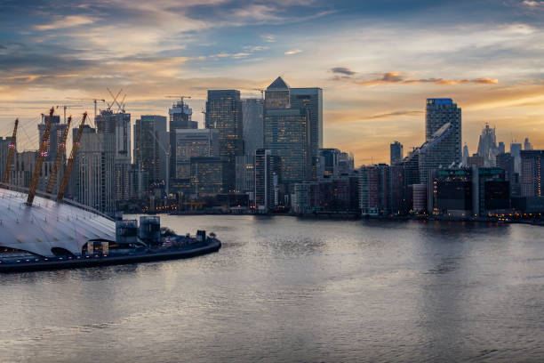 Aerial view over the Thames in London to the financial district Canary Wharf Aerial view over the Thames in London to the financial district Canary Wharf with the modern skyline just after sunset london docklands stock pictures, royalty-free photos & images