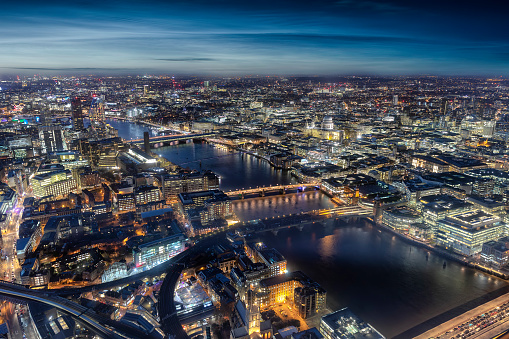 Aerial view of London by night with the famous bridges along the river Thames and major sightseeing attractions, UK