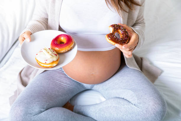 istock Pregnant woman eats a tasty doughnut 1082377770