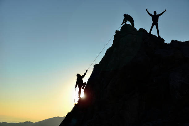 istock rock climbing struggle and peak success 1082389106