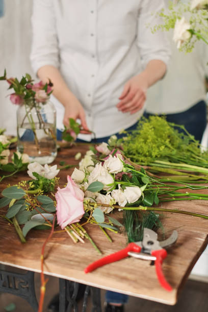 istock hands of florist collect wedding bouquet at work 1082401134