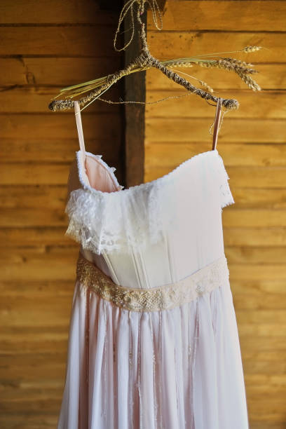 wedding dress on a hook on a wooden covering