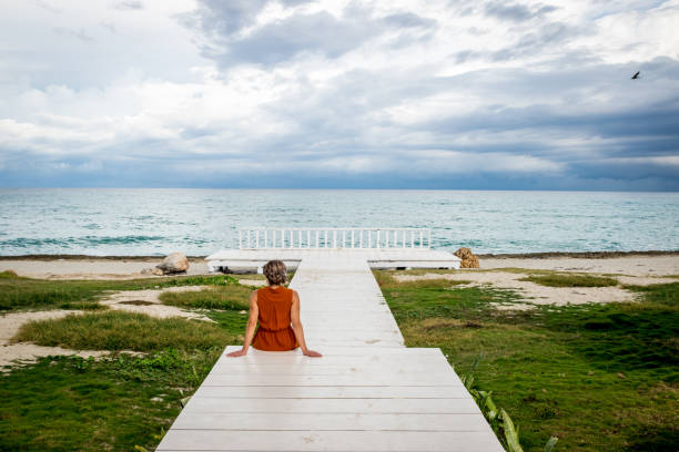 istock Woman on a wooden path by the beach 1082419288