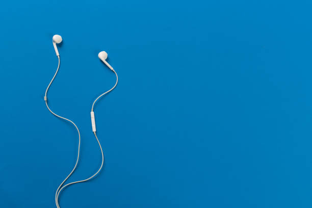 istock White earphones on blue background 1082421586
