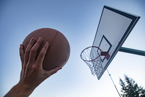 Young Man Holding a Basketball Ball and Aiming at Basket.
