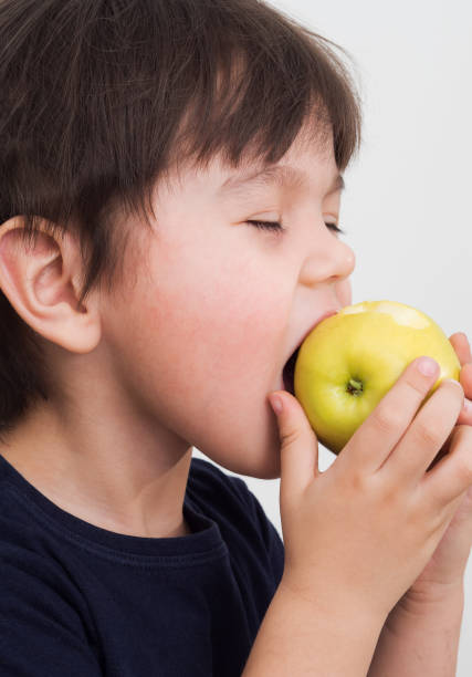 istock A little boy holds a green Apple in his hands 1082429358