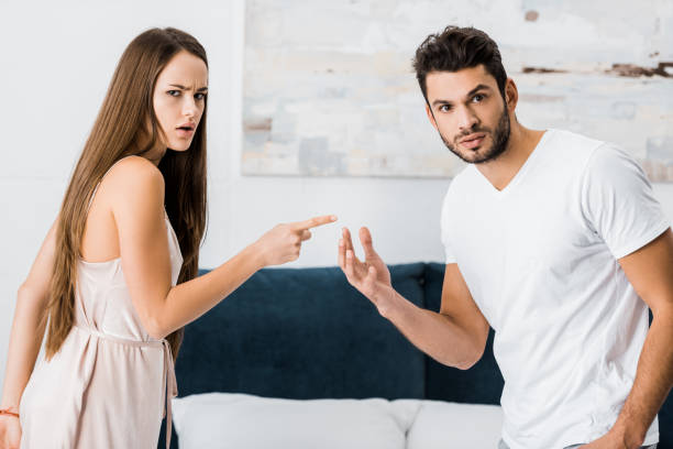 istock young attractive woman pointing with finger angrily at man 1082434502