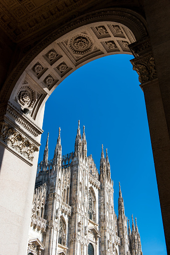Duomo cathedral view through arched window in Milan, Italy.