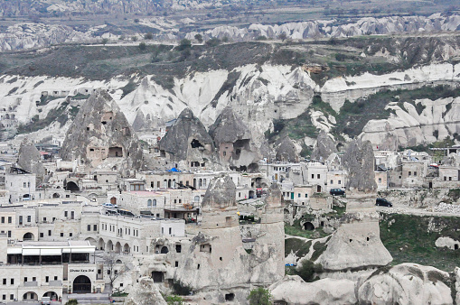 Rocky geological formations, fairy chimneys and a small town at Cappadocia historical region in Turkey.