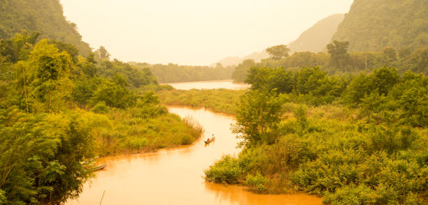 barco con vistas sobre el río nam ou y las montañas de piedra caliza de la aldea de muang ngoi en laos - laos hut southeast asia shack fotografías e imágenes de stock