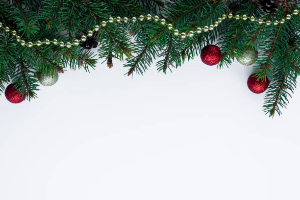 istock Green christmas tree branches with cones. Gold chain, red and gold baubles as a decorative frame on white background, with copy space. 1082447674