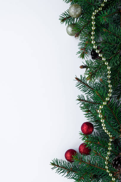istock Christmas decorations: green conifer tree branches, red and gold baubles and chain. Festive vertical greeting card with copy space. 1082447678