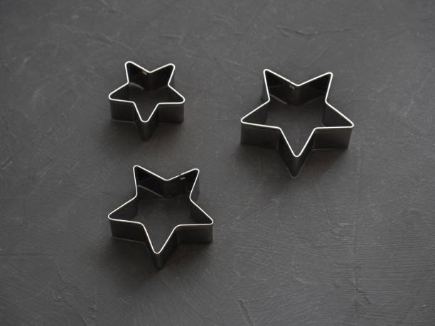 istock Metal stars on black festive background. Baking molds. Cookie cutters. Flat lay, top view 1082453620