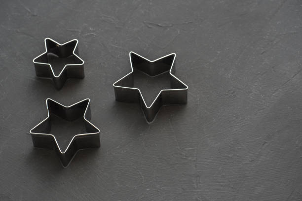 istock Metal stars on black festive background. Baking molds. Cookie cutters. Flat lay, top view 1082453662