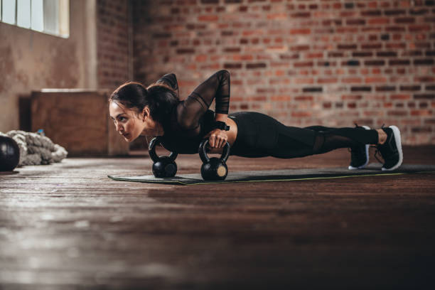 fit donna che fa un intenso allenamento di base in palestra - kettle bell sport women muscular build foto e immagini stock