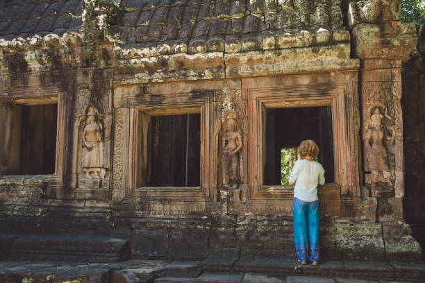 vista trasera de una mujer adulta media parada fuera del templo ankor wat - ankor fotografías e imágenes de stock