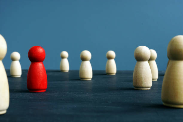 istock Uniqueness, originality, difference and distinction. Wooden figures and red one. 1082457848