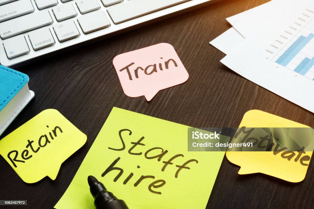 Staff hire, train, motivate and retain written on a memo sticks. Employee Stock Photo