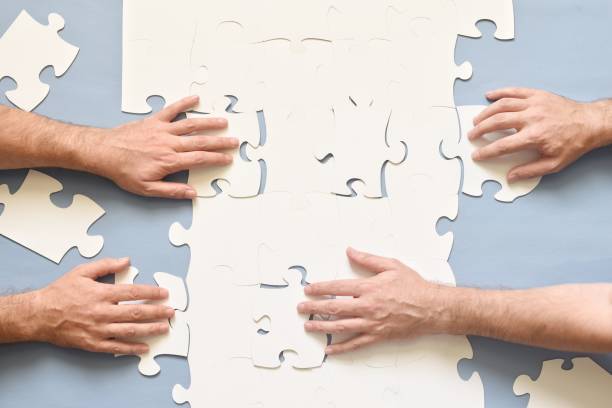istock Close-Up Of Hand Arranging Jigsaw Puzzle 1082460634