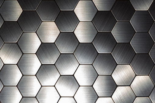 Modern background with a metal hexagons and a black outline. Macro shot.