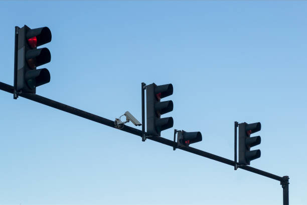 caméra de surveillance extérieure et quatre feux rouges installé sur un poteau au-dessus de la chaussée, avec un ciel bleu, copie espace - copy space road sign sky above photos et images de collection