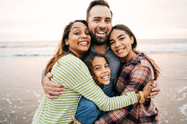 lächelnden eltern mit zwei kindern - family smiling adult love stock-fotos und bilder