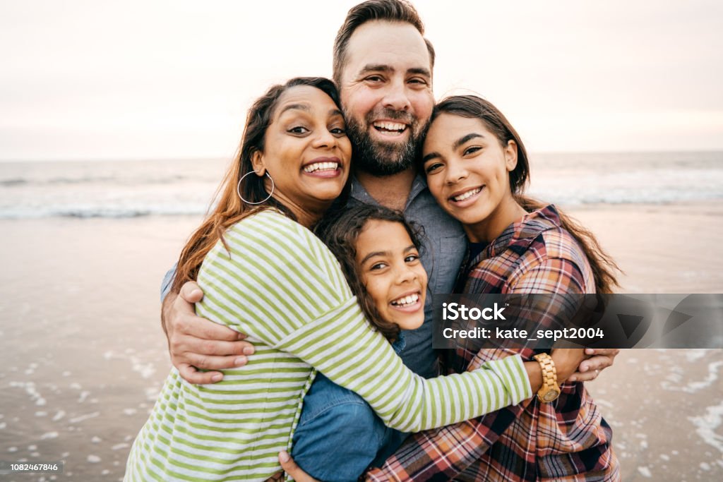 Smiling parents with two children Smiling parents with two children on the beach Family Stock Photo