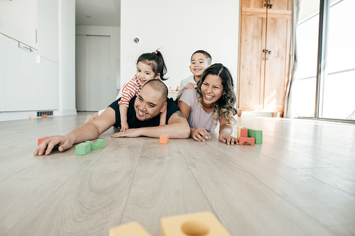 A family lying on a wood flooring.