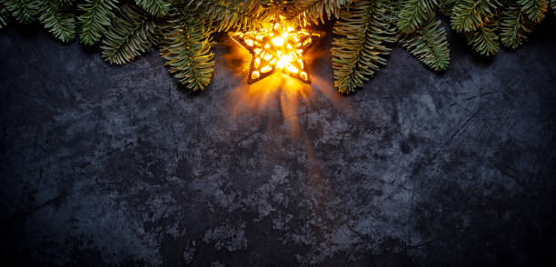 estrela de natal dourada em metal escuro - holiday background galho de árvore do abeto - christmas tree fir tree branch christmas - fotografias e filmes do acervo