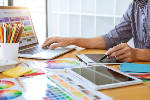 istock Young creative graphic designer working on project architectural drawing and color swatches, selection coloring on graphic chart with work tools and equipment 1082469910