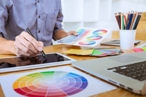 istock Young creative graphic designer working on project architectural drawing and color swatches, selection coloring on graphic chart with work tools and equipment 1082469918