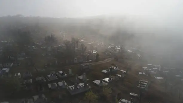 Photo of Aerial view  about the cemetery on a foggy morning In Sic village, Transyvania, Romania.