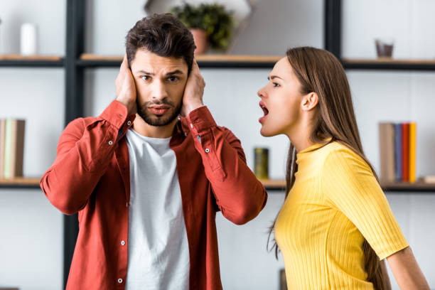 istock selective focus of angry girlfriend screaming at boyfriend while man putting hands on ears 1082471024