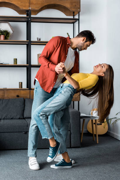 istock handsome bearded man dancing with attractive girlfriend in living room 1082471038