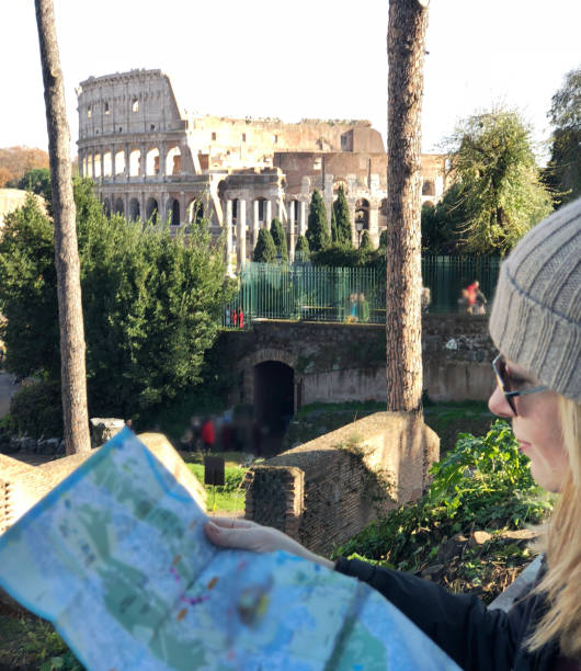 istock Admiring the Colosseum and Palatin hill while checking map of Rome 1082473620