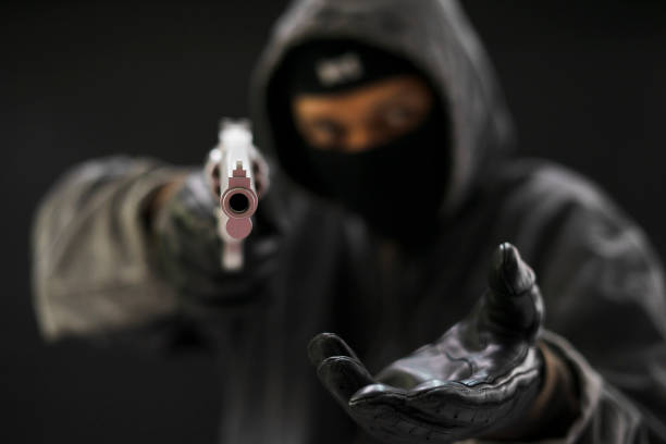 istock Robber with a gun robbing intimidate.Crime and robbery concept. 1082477828