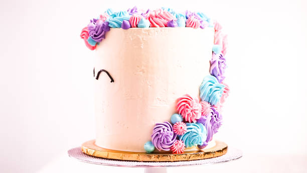 istock Piping unicorn eyes with a black buttercream icing on a white cake. 1082485658