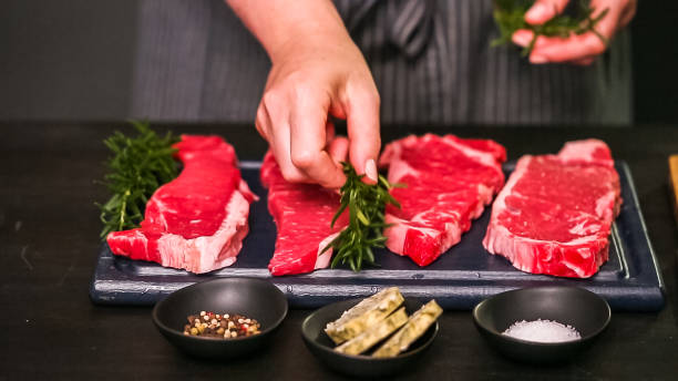 istock Raw New York strip steaks on a wood cutting board. 1082486294
